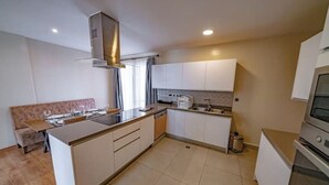 Een moderne keuken met witte kasten, een centraal eiland en een inbouwoven.
