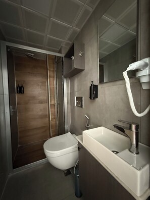 Een douche, een regendouche, een haardroger, pantoffels