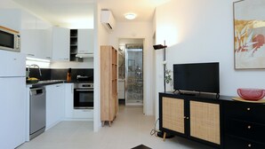 A modern kitchen with white cabinetry, a built-in oven, and a microwave.