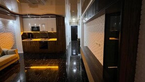 Een modern interieur met een keuken, een bank en een gang.