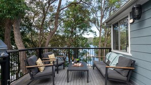 Une terrasse dotée de mobilier d’extérieur, d’une table et offrant une vue sur un lac.
