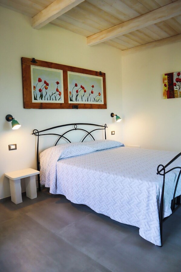 A bedroom with a bed, bedside tables, and wall-mounted lamps. - Il FicOlivo (Pitigliano)