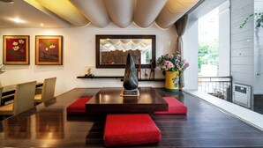 Um interior moderno com área de refeições, um espelho grande e vista para o exterior.