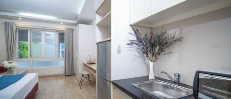 A modern kitchen with a built-in toaster, a sink, and a window with curtains.