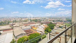 Un edificio alto con barandilla de vidrio y vistas a un paisaje urbano.