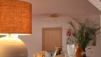 A room with a lamp, a vase with flowers, and a decorative bowl on a wooden table.