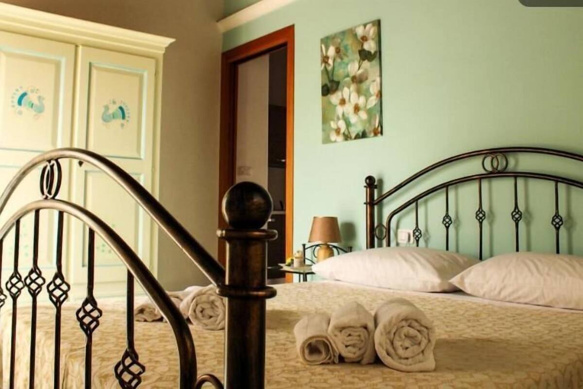 Un dormitorio con cama, mesita de noche y un cuadro en la pared.