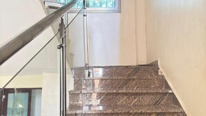 A staircase with a metal handrail and glass panels. - Lux Suites Lakeview Mansion Nakuru (Nakuru)