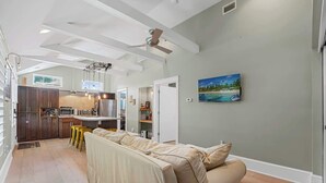 Una cocina moderna con comedor, ventilador de techo y un cuadro en la pared.