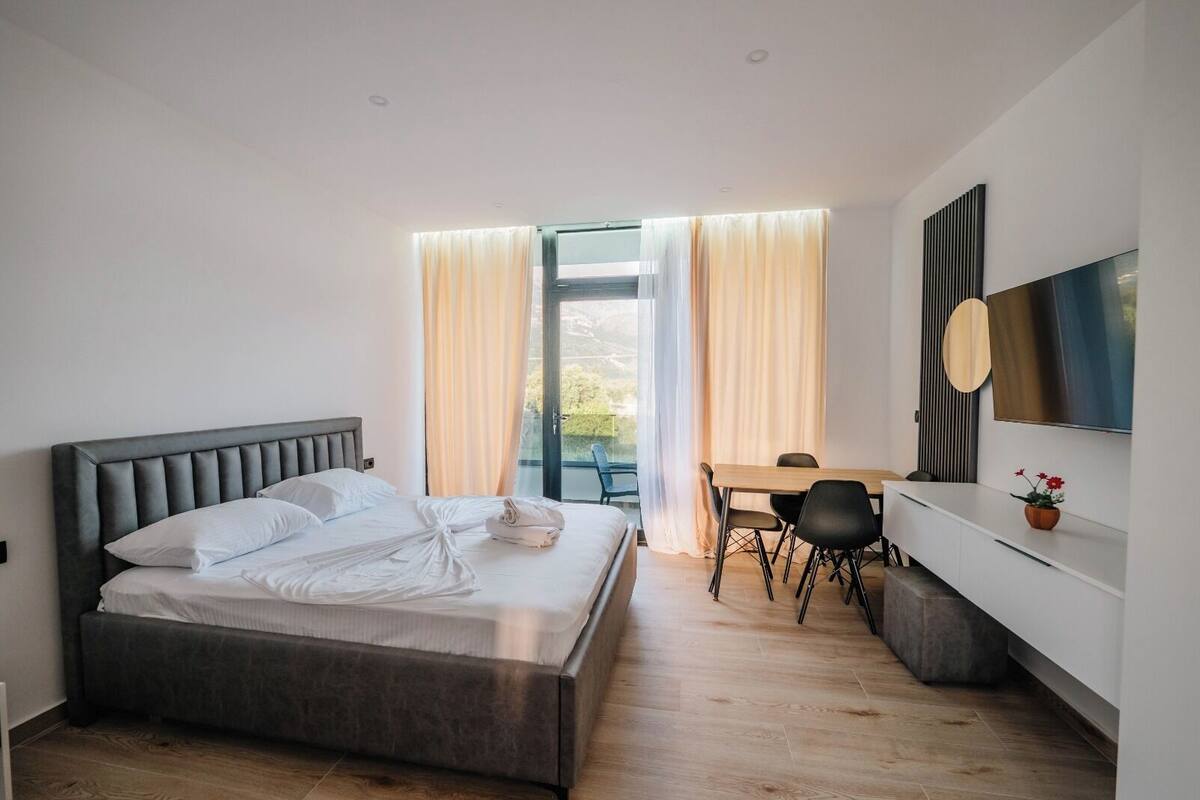 Een moderne slaapkamer met een groot bed, een bureau en een televisie.