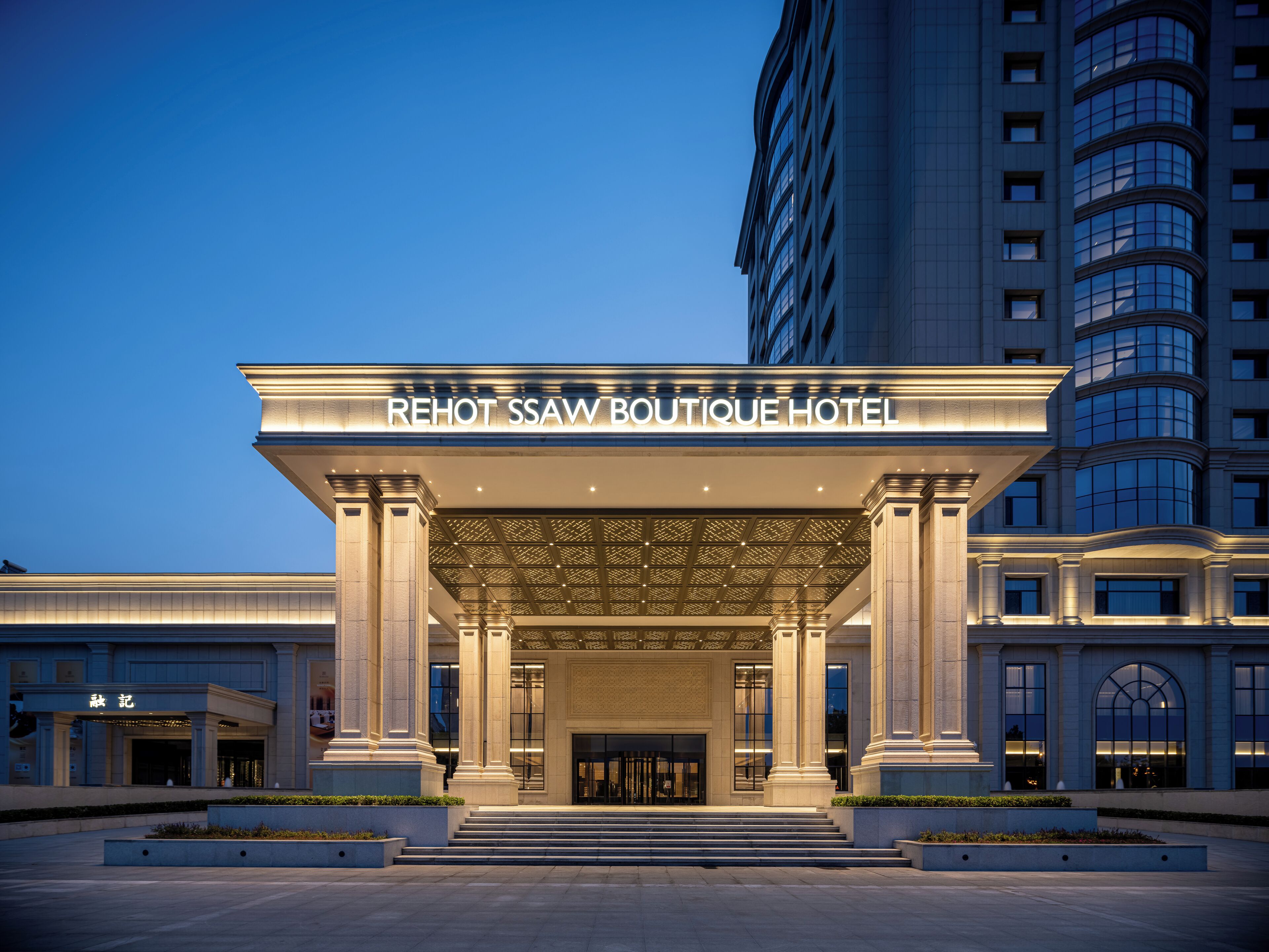 The entrance of the Rehot SSaw Boutique Hotel with a grand facade, large columns, and a prominent entrance.