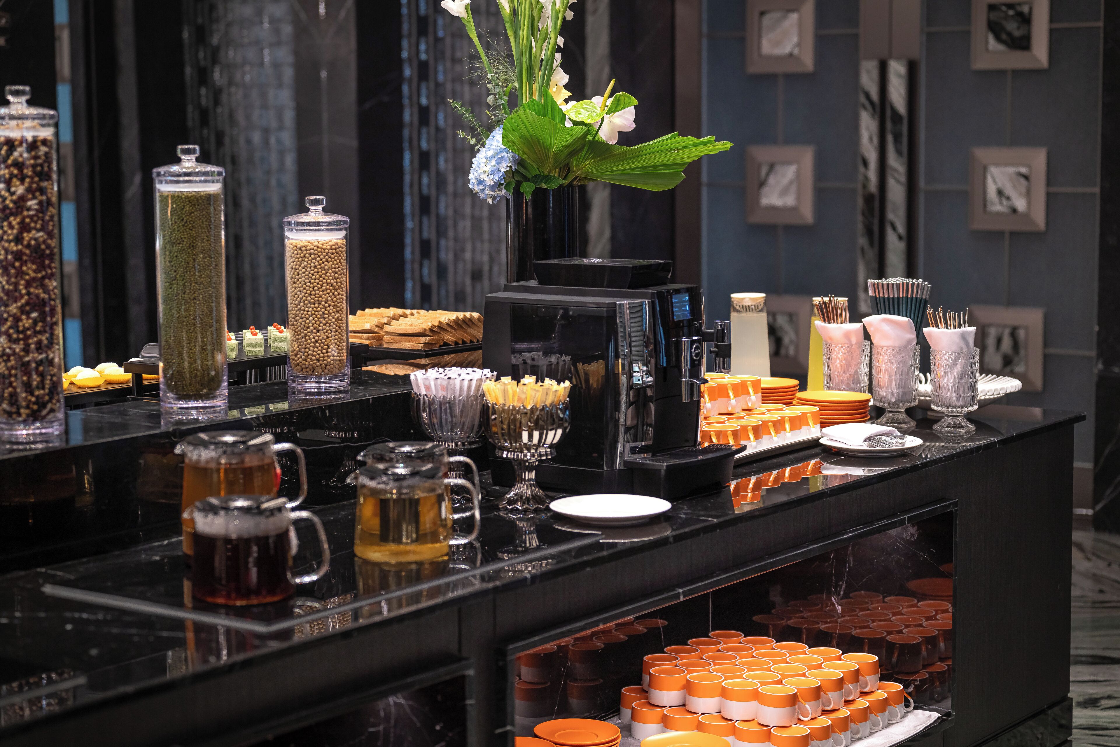 A buffet with various food items, beverages, and a coffee machine.