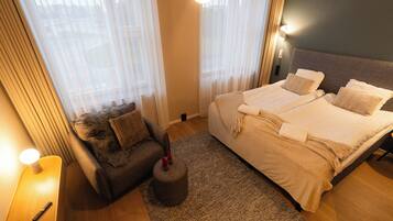 Una habitación de hotel con cama, sofá, alfombra y lámpara.