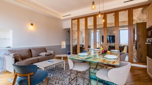 A modern living room with a glass dining table, a sofa, and a coffee table.