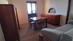 Une petite pièce comprenant un lit, un bureau en bois, une chaise et une table.