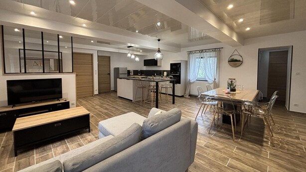 A modern living room with a sofa, TV, and dining area with chairs and a table. - Modern 3-ears cottage in Cognat-Lyonne, 6 ppl, charm and comfort (Cognat-Lyonne)