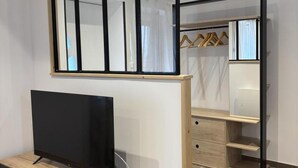 A modern room with a TV on a wooden stand, a wardrobe with hanging space, and a mirror above the TV. - Modern 3-ears cottage in Cognat-Lyonne, 6 ppl, charm and comfort (Cognat-Lyonne)