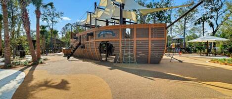 A pirate-themed play area with a ship structure, slides, and a playground.