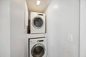 A laundry room with two stacked washing machines.