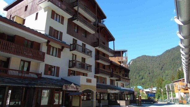 Un hôtel à plusieurs étages doté de balcons, d’un télésiège et situé dans un cadre montagneux.