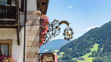 A building with a sign reading "Gasthof Loven" and a balcony with flowers.