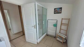 Ein Zimmer mit einer Schiebeglastür, einem Heizkörper, einer kleinen Holzleiter und einem gerahmten Bild an der Wand.