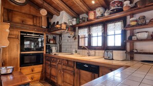 Una cocina con armarios de madera, lavavajillas Bosch, estufa y pileta.