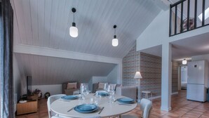 A dining area with a round table set for four, two pendant lights, and a patterned wall in the background. - Duplex 83m², 3 bedrooms, 6 pers, central Saint-Gervais, 5 min to cable car, Wifi included (Saint-Gervais-les-Bains)