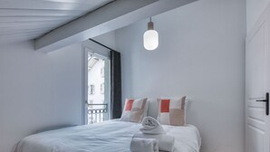 A modern bedroom with a bed, a window, and a hanging light fixture. - Duplex 83m², 3 bedrooms, 6 pers, central Saint-Gervais, 5 min to cable car, Wifi included (Saint-Gervais-les-Bains)