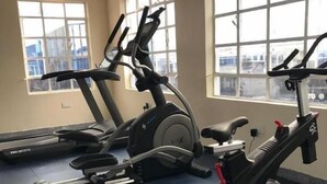 A gym with two stationary bikes and a treadmill.