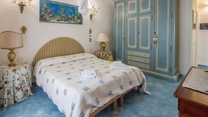 Ein Schlafzimmer mit einem Bett, Nachttischen, einem Kleiderschrank und einem Bild an der Wand.