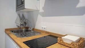 A modern kitchen with a stainless steel sink, a microwave, and a built-in induction cooktop.