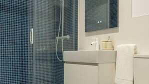 A bathroom with a glass shower enclosure, a white sink, and a toilet. - Apartments EL Aljibe - Ap.1 (Badajoz)