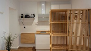 A compact kitchen with white cabinets, a wooden countertop, and a built-in stove. - EL Aljibe Apartments - Ap.4 (Badajoz)