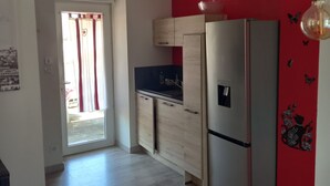 Une cuisine moderne équipée d’un réfrigérateur, d’un évier et de meubles de rangement en bois.
