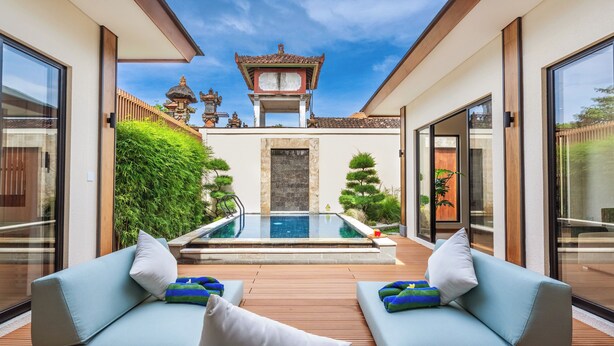Ein moderner Poolbereich im Freien mit zwei Sofas und einer traditionellen Pagode im Hintergrund.