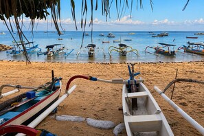 Une plage avec plusieurs bateaux ancrés dans l’eau et une rive sablonneuse.