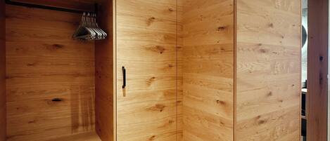 Un armario moderno de madera con barra para colgar y una puerta.