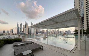 Outdoor pool - Manzil - Stylish 1BR in Emaar Beachfront (Dubai)