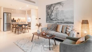 Un salon moderne avec un canapé, une table basse et des œuvres d’art accrochées au mur.