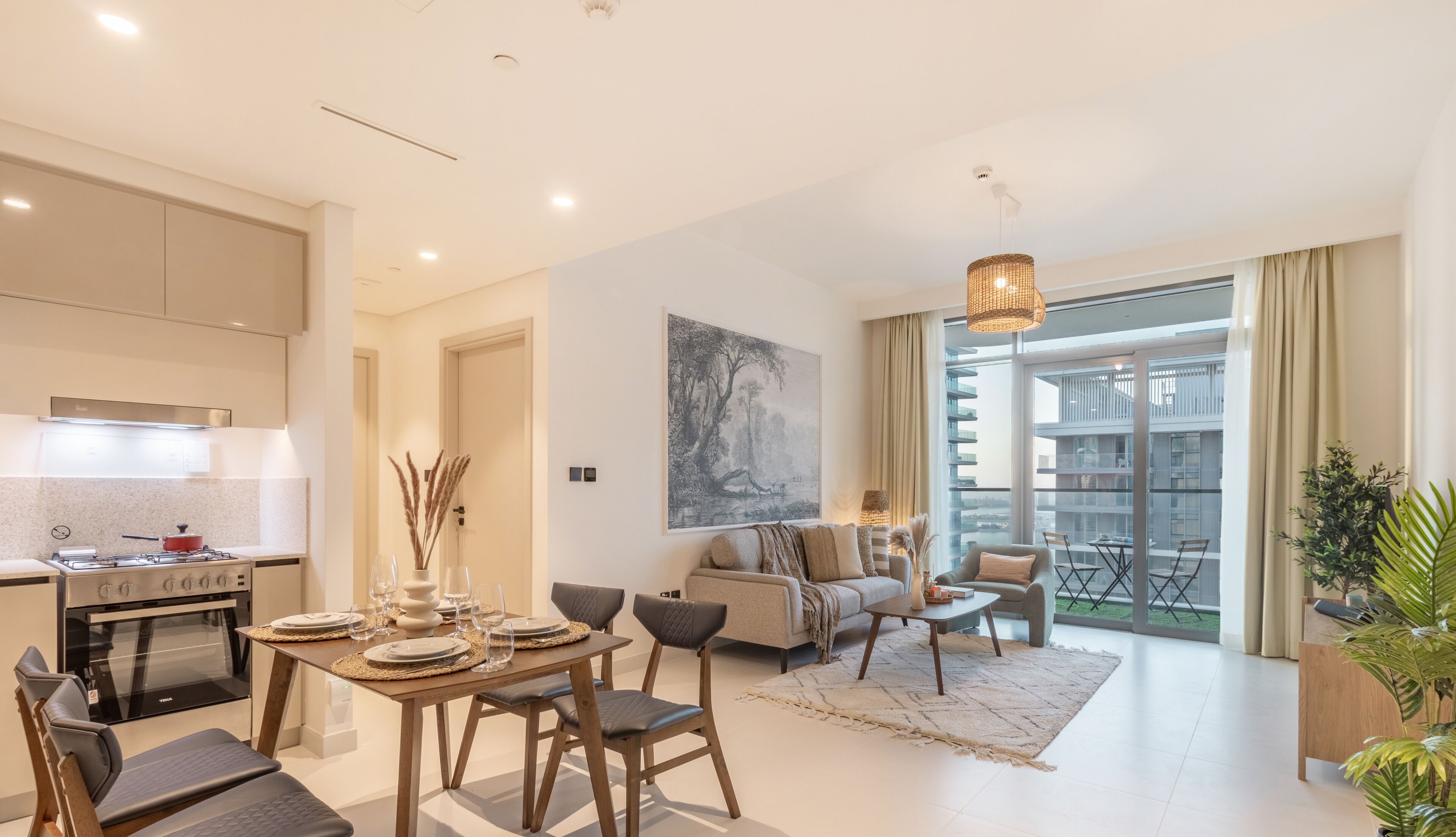 Un appartement moderne comprenant un coin repas, une cuisine, un salon et de grandes fenêtres offrant une vue sur la ville.