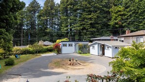A residential area with a small house, a garage, and a driveway. - Cottagecore charm beside the redwoods—steps to trails, minutes to beaches and downtown Arcata. (Arcata)