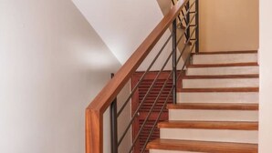 Una escalera con escalones de madera y barandilla de metal.