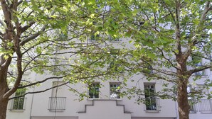 A two-story building with a white facade, numbered 12, and a door at the center.