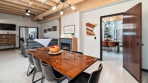 A modern dining area with a wooden table, chairs, and a fireplace.