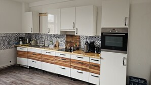 A modern kitchen with white cabinets, a patterned backsplash, and a built-in oven.