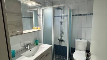 Een haardroger, handdoeken, zeep, toiletpapier