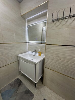 A modern bathroom with a white sink, a mirror, and a shower curtain. - Boulevard Guest House by SamApart (Samarqand)