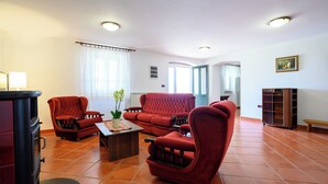 Un salon avec des canapés rouges, une table basse en bois et une cheminée.