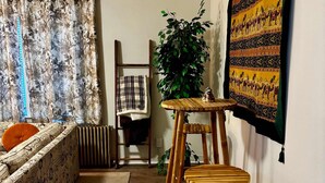 Ein Wohnzimmer mit einer Couch, einem Holztisch und einem großen Wandteppich.